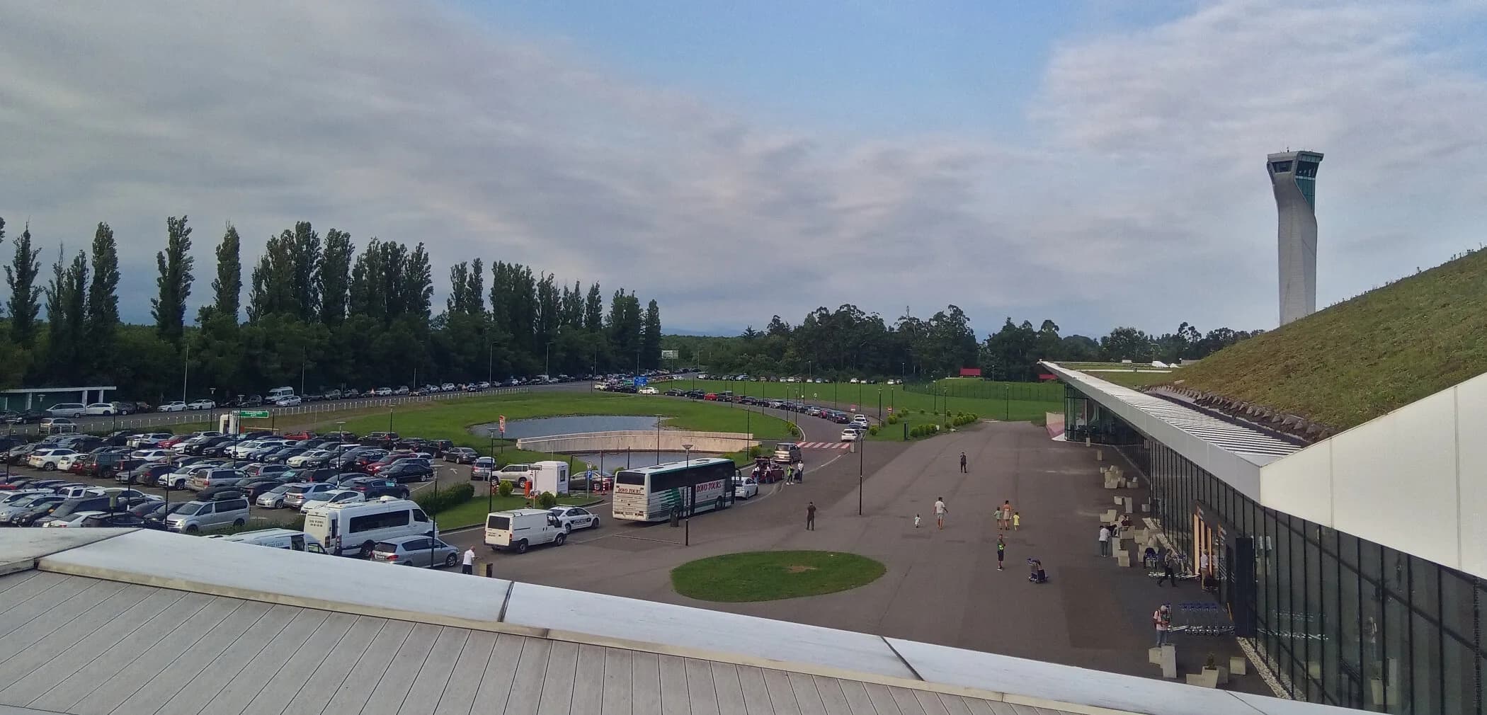 The forecourt of Kutaisi International Airport: shuttle buses, minibuses, the car park and the control tower